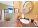 Well-lit bathroom features a vintage sink, and decorative mirror with a view to toilet and shower at 16531 San Edmundo Rd, Punta Gorda, FL 33955