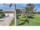 Charming single-story home with well-manicured lawn, palm trees and a two car garage at 16531 San Edmundo Rd, Punta Gorda, FL 33955