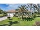Well-maintained front yard with a large palm tree, green grass, and a view of the home's facade at 16531 San Edmundo Rd, Punta Gorda, FL 33955
