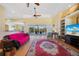 Bright living room featuring hardwood floors, built-in shelving, and access to the pool area at 16531 San Edmundo Rd, Punta Gorda, FL 33955