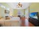 Spacious main bedroom features a ceiling fan, hardwood floors, tray ceiling, and large television for relaxing at 16531 San Edmundo Rd, Punta Gorda, FL 33955