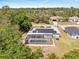 Charming home featuring a screened-in pool, solar panels and lush surrounding trees and landscaping at 1702 Rice Ter, North Port, FL 34286