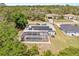 Charming home featuring a screened-in pool, solar panels and lush surrounding trees and landscaping at 1702 Rice Ter, North Port, FL 34286
