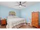 Cozy bedroom with a ceiling fan, wood floors, and a window allowing natural light at 1702 Rice Ter, North Port, FL 34286