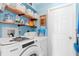 Functional laundry room with modern appliances, shelving, and ample storage space at 1702 Rice Ter, North Port, FL 34286