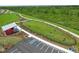 Aerial view of a fully fenced dog park with play equipment and a walking path amidst lush greenery at 17612 Fallen Branch Way, Punta Gorda, FL 33982