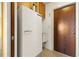 View of kitchen area with vintage fridge, sink, wooden door, and upper cabinets at 18422 Arapahoe Cir, Port Charlotte, FL 33948