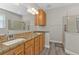 Bathroom with double granite vanity, large mirror, tile flooring, and walk-in glass shower at 1859 Scarlett Ave, North Port, FL 34289