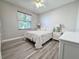 Cozy bedroom features a stylish accent wall, complemented by wood-look floors and a view to the outside at 1859 Scarlett Ave, North Port, FL 34289