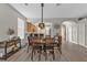 Elegant dining area featuring a stylish light fixture, hardwood floors, and an open layout to the kitchen at 1859 Scarlett Ave, North Port, FL 34289