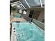 Close up shot of screened-in hot tub on lanai next to pool at 1859 Scarlett Ave, North Port, FL 34289
