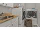 Convenient laundry room with granite countertop, stainless steel sink, washer, dryer, and basket storage at 1859 Scarlett Ave, North Port, FL 34289