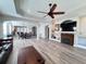 Spacious living room featuring an open floor plan and a decorative fireplace with large ceiling fan at 1859 Scarlett Ave, North Port, FL 34289