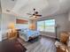 Spacious main bedroom with tray ceiling, ceiling fan and serene natural light from large windows at 1859 Scarlett Ave, North Port, FL 34289