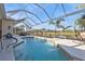 Relaxing screened-in pool area with a beautiful waterfront view and mature tropical landscaping at 1859 Scarlett Ave, North Port, FL 34289