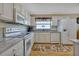 Well-lit kitchen boasts white cabinetry, granite counters, and modern appliances at 1944 Boddington Trl, Port Charlotte, FL 33980
