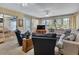 Bright living room featuring a large sofa, recliners, and views of the lush outdoors at 1944 Boddington Trl, Port Charlotte, FL 33980