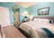 Bedroom featuring blue walls, queen bed, wood-look floors and coastal accents at 2002 Bal Harbor Blvd # 311, Punta Gorda, FL 33950