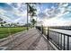 Picturesque boardwalk with brick pavers, palm trees, and water views, leading to a pier at 2002 Bal Harbor Blvd # 311, Punta Gorda, FL 33950