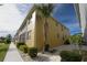 Exterior view of a multi-story yellow building with a well-maintained lawn and landscaping at 2002 Bal Harbor Blvd # 311, Punta Gorda, FL 33950