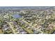 A picturesque aerial view of a community featuring lush greenery, a tranquil lake, and well-maintained homes at 206 Santarem Cir, Punta Gorda, FL 33983