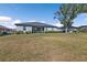 Spacious backyard features a large lawn, covered patio, and mature landscaping, perfect for outdoor entertaining at 206 Santarem Cir, Punta Gorda, FL 33983