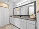 Double-sink bathroom vanity featuring granite counters and framed mirror with a view of the shower at 206 Santarem Cir, Punta Gorda, FL 33983