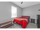 Bedroom with red comforter, a gray wall, and a small window at 206 Santarem Cir, Punta Gorda, FL 33983