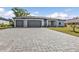 The home features a three-car garage and is situated on a well-manicured lawn with a paved driveway at 206 Santarem Cir, Punta Gorda, FL 33983