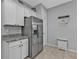 Bright kitchen with stainless steel refrigerator, pantry, and modern countertops at 206 Santarem Cir, Punta Gorda, FL 33983