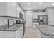 Well-lit kitchen featuring white cabinets, granite countertops, and stainless steel appliances at 206 Santarem Cir, Punta Gorda, FL 33983