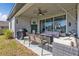 Relaxing patio area with ceiling fan, outdoor grill, seating and large green backyard at 206 Santarem Cir, Punta Gorda, FL 33983