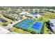 Aerial view showcasing the community's pickleball courts, clubhouse, and a serene lake at 2061 Willow Hammock Cir # 105, Punta Gorda, FL 33983