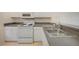 Kitchen features a stainless steel sink, tile flooring, and white appliances at 2061 Willow Hammock Cir # 105, Punta Gorda, FL 33983
