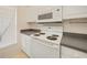 Kitchen features a stainless steel sink, tile flooring, and white appliances at 2061 Willow Hammock Cir # 105, Punta Gorda, FL 33983