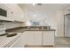 Bright kitchen with stainless steel sink, appliances, white cabinetry and view to an open living space at 2061 Willow Hammock Cir # 105, Punta Gorda, FL 33983