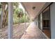A long covered porch with columns offers shady views to tropical plants and sky at 231 Winson Ave, Englewood, FL 34223