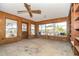 Cozy living room with wood-paneled walls, a ceiling fan, and multiple windows offering plenty of natural light at 231 Winson Ave, Englewood, FL 34223