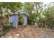 A rustic shed is nestled amongst the trees, providing outdoor storage and garden workspace at 231 Winson Ave, Englewood, FL 34223