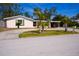 Cozy single-story home with a carport, circular driveway, and verdant palm trees at 2521 Clipper Ship Way, Sarasota, FL 34231