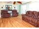 Cozy living room with armchairs, leather sofa, and rustic bamboo floors at 2521 Clipper Ship Way, Sarasota, FL 34231