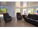 Comfortable living room features a large window, tile floors, and leather furniture at 2521 Clipper Ship Way, Sarasota, FL 34231