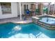 This backyard pool features a brick-paved deck, a fountain, and a hot tub with colorful tile trim, providing a perfect outdoor oasis at 2521 Clipper Ship Way, Sarasota, FL 34231