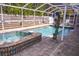 A screened-in pool area showcases a tiled spa, dolphin statue water feature, and brick-paved deck, perfect for outdoor relaxation at 2521 Clipper Ship Way, Sarasota, FL 34231