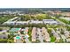 The aerial view reveals residential buildings near tennis courts and baseball fields amidst lush greenery at 2717 Hidden Lake Blvd # C, Sarasota, FL 34237