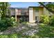 Exterior view features a screened-in patio with green lawn and landscaping at 2717 Hidden Lake Blvd # C, Sarasota, FL 34237