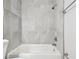 Modern bathroom featuring a shower-tub combination with gray marble tiling and updated fixtures at 2717 Hidden Lake Blvd # C, Sarasota, FL 34237
