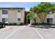 Condo exterior featuring stairs to the units, parking, and green landscaping with a mature tree at 2717 Hidden Lake Blvd # C, Sarasota, FL 34237