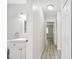 Hallway view featuring updated white bathroom vanity and light gray plank floors at 2717 Hidden Lake Blvd # C, Sarasota, FL 34237