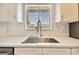 Updated kitchen with stainless steel faucet, white cabinets, and blind-covered windows at 2717 Hidden Lake Blvd # C, Sarasota, FL 34237